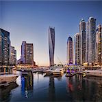 Dubai Marina at twilight with the Cayan Tower (Infinity Tower), the Dubai Marriott Harbour Hotel and Suites and various residential towers, Dubai Marina, Dubai, The United Arab Emirates.