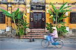 Woman riding bicycle past restaurant, Hoi An (UNESCO World Heritage Site), Quang Ham, Vietnam