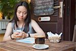 Woman drinking iced coffee in cafe, Hoi An (UNESCO World Heritage Site), Quang Ham, Vietnam (MR)