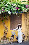 Woman wearing Ao Dai dress with bicycle, Hoi An (UNESCO World Heritage Site), Quang Ham, Vietnam (MR)