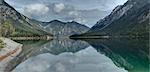Scenic view of mountains reflected in a clear lake (Plansee) in autumn, Tirol, Austria