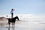 Horse rider standing on horse, Pakiri Beach, Auckland, New Zealand
