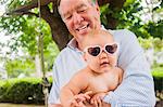 Portrait of grandfather and baby granddaughter in heart shaped sunglasses