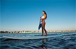 Young woman stand up paddleboarding, Mission Bay, San Diego, California, USA