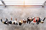 Overhead view of business team in a row jumping for joy