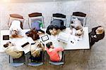 Overhead view of exhausted business team leaning on desk in office