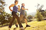 Mature couple power walking in park