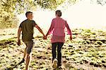 Rear view of mature couple power walking in park