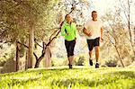 Mature couple running through park