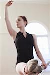 Teenage ballerina dancing at the barre in ballet school