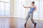 Teenage girl warming up with alternative dance in ballet school