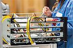 Midsection of female engineer repairing computer part in electronics industry