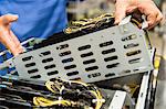 Midsection of male technician examining video card in computer manufacturing industry