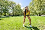 Full length of tired fit woman taking a break while exercising in park