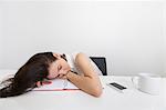 Tired businesswoman sleeping at desk in office