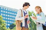 Male and female students using digital tablet at college campus