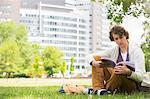 Full length of young man reading book on college campus