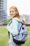 Portrait of happy young woman with backpack at college campus