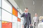 Middle aged businessman on call while walking in railroad station