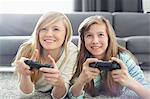 Sisters playing video games in living room