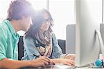 Creative business colleagues using desktop computer in office