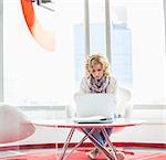 Businesswoman using laptop in creative office