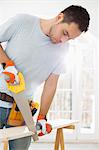 Man sawing wood in new house