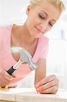 Mid-adult woman nailing in table