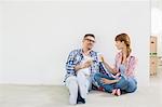 Full-length of couple having coffee in new house