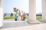 Family with cardboard boxes entering into new house