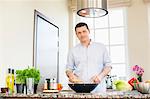 Portrait of confident man preparing food in kitchen