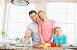 Portrait of happy family preparing food in kitchen