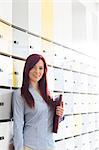 Portrait of beautiful businesswoman holding file in locker room at creative office