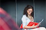 Happy businesswoman reading book in office