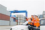 Workers examining cargo in shipping yard