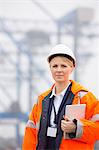 Female engineer holding tablet PC in shipping yard