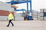 Full-length of female worker walking in shipping yard