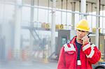 Male worker using walkie-talkie in shipping yard