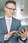 Middle-aged businessman using tablet PC in office