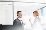 Businessman and businesswoman having coffee in office