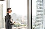 Side view of mature businessman looking through office window