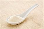 collagen protein powder on a white Chinese spoon against burlap canvas