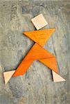 abstract of a dancing, running or walking figure built from seven tangram puzzle wooden pieces,, the artwork copyright by the photographer