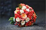 Beautiful Bridal bouquet of various flowers on asphalt.