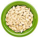 fresh pumpkin seeds in an isolated green ceramic bowl