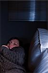 Girl sleeping on a couch in semi-darkness of her living room