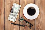 Money cash, glasses, pen and coffee cup on wooden table