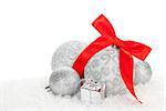 Christmas baubles and red ribbon over snow with copy space