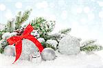 Christmas baubles and red ribbon over snow bokeh background with copy space