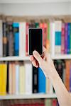 blank screen smartphone in woman hands at library